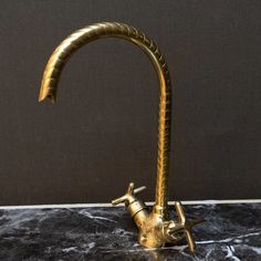 a brass faucet on a marble counter top