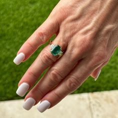 This Emerald & Diamond Cocktail Ring showcases a stunning 4.00-carat emerald-cut Zambian emerald, certified by GIA for its exceptional quality (F2 grade). Flanking the vibrant green emerald are two elegant trapezoid diamonds, totaling 0.70 carats (G color, VS clarity), adding brilliance and symmetry to the design. In a classic 18 karat yellow gold setting, this size 6.25 ring exudes timeless sophistication (can be sized), and measures 10 x 15mm on top. Gia Certified Octagon Emerald Ring In White Gold, Gia Certified White Gold Octagon Emerald Ring, Gia Certified Octagon Emerald Ring, Gia Certified Formal Emerald Cut Emerald Ring, Luxury Emerald Ring With Radiant Cut, Radiant Cut Emerald Ring Luxury, Luxury Gia Certified Emerald Ring For May Birthstone, Elegant Octagon Gia Certified Emerald Ring, Gia Certified Emerald-cut Diamond Ring