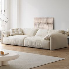 a living room with white furniture and wood floors