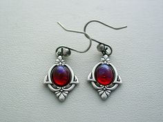 "For more fire opal jewelry, please visit https://www.etsy.com/shop/JJsCollections?search_query=3db Dragons Breath Fire Opal Art Deco Earrings Classic Vintage Glass Cabochon Earrings Oxidized Finish Dragons Breath is a translucent rose color with streaks of violet. This is a vintage glass cabochon The earrings dangle 1 1/2\", 32mm from fish hook. Setting measures almost 7/8\", 23mm The settings are oxidized silver finish As with any vintage cabochon design, there are always natural inclusions or Dragons Breath Fire Opal, Dragon Breath, Mineral Crystals, Glass Dragon, Opal Art, Fire Opal Earrings, Fire Opals Jewelry, Cabochon Earrings, Butterfly Wing Earrings