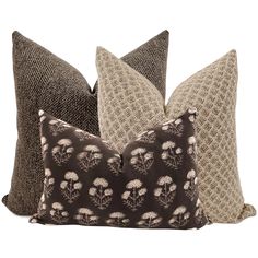 three pillows with different patterns on them, one is brown and the other is beige