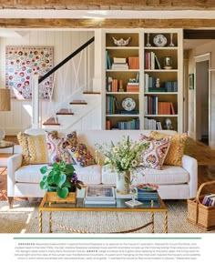 a living room filled with furniture and bookshelves next to a stair case full of books