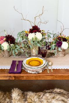 the table is set with flowers and silverware for an elegant fall wedding reception or bridal party