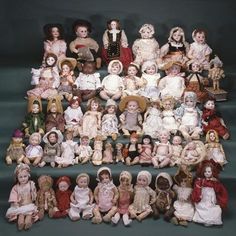 a large group of dolls sitting next to each other