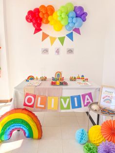 a rainbow themed birthday party with balloons and decorations