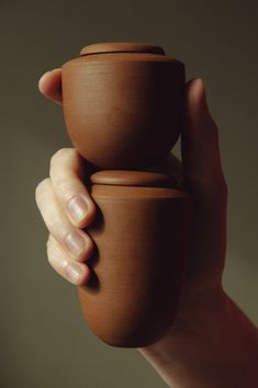 a person holding a clay pot in their hand