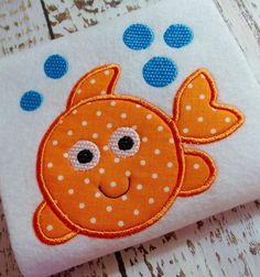 an orange fish with polka dots on it's face is sitting on a white surface