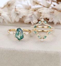 three different rings with green and white stones