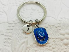 Cowboy Hat Keychain, Cowgirl Hat Keychain, Personalized Keychain, Initial Keychain, Cowboy Hat Charm, Initial Charm, Initial Key Ring Express yourself with a beautiful piece of charm jewelry or find the perfect gift for that special person! This keychain features a blue enamel and silver cowboy or cowgirl hat charm and an initial charm *Charms are made from a zinc alloy metal and are lead and nickel free. 🌺I offer 5 different styles of initials (the keychain is shown with the stamped circle sty Blue Cap Hat As A Gift, Blue Cap As Gift, Blue Cap As A Gift, Handmade Adjustable Hats For Gifts, Handmade Adjustable Silver Hats, Adjustable Silver Hat As Gift, Personalized Adjustable Hats As Gifts, Handmade Blue Hat For Gift, Handmade Blue Hat As Gift