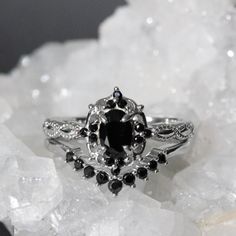 a black and white diamond ring sitting on top of crystals