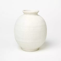 a white vase sitting on top of a table