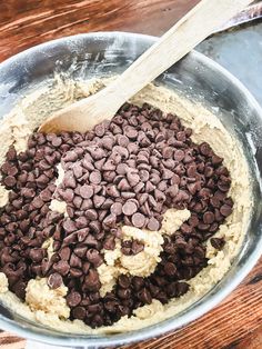 a metal bowl filled with chocolate chips and batter