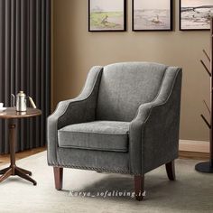 a living room with a gray chair and two pictures on the wall