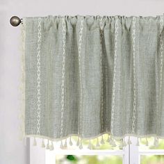 a curtain with tassels hanging in front of a window