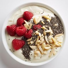 a white bowl filled with yogurt and raspberries on top of it