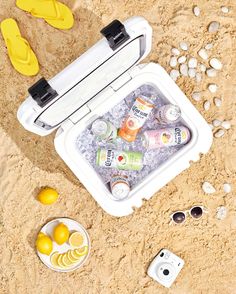 an ice chest on the beach with lemons and water