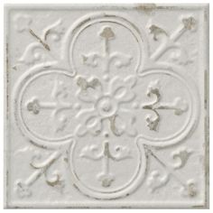 a white tile with an ornate design on it