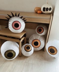 several rolls of white yarn sitting on top of a wooden table next to pumpkins