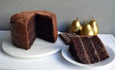 a piece of chocolate cake on a white plate next to a slice of chocolate cake