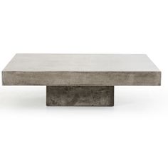 a concrete coffee table sitting on top of a white floor