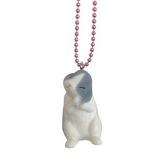 a white and gray cat with pink beads on a necklace that is hanging from a ball chain