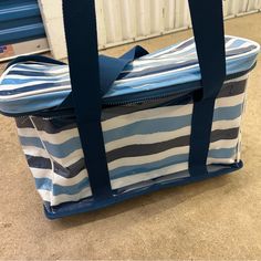 a blue and white striped bag sitting on the floor