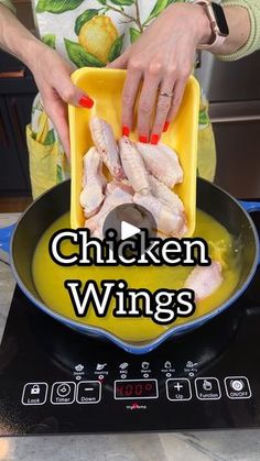 a woman cooking chicken wings in a pan on top of a stove with the words chicken wings above it