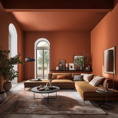 a living room with an orange wall and brown furniture in the center, surrounded by potted plants