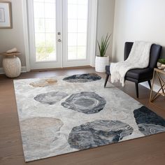 a living room area with a rug, chair and potted plant on the floor