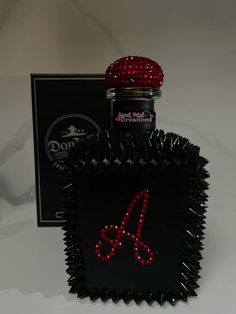 a black bottle with red letters on it and a box in the background that says don't miss diamonds