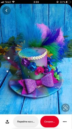 a colorful hat with feathers and bows on a blue wooden surface