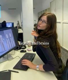 a woman sitting in front of a computer monitor with the caption beauty and brains