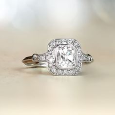 This stunning platinum halo-style engagement ring features a GIA-certified 1.10-carat antique cushion cut diamond with G color and SI1 clarity. Decorating the diamond is a diamond halo as well as more diamonds along the shoulders. The platinum ring features a lovely under-gallery.   ✦DIAMOND SPECIFICATIONS:   GIA- Certification: GIA- Certifiacte   Diamond Weight: 1.10-Carats   Diamond Color: G Color   Diamond Clarity: SI1 Clarity   Diamond-Cut: Cushion Cut ✦ ENGAGEMENT RING SPECIFICATIONS: Ring Classic Gia Certified Diamond White Halo Ring, Vintage White Diamond Ring With Halo Setting, Heirloom Cushion Cut Diamond White Ring, Classic Gia Certified Square Cut Diamond Ring, Classic Square Cut Gia Certified Diamond Ring, Classic Gia Certified Cushion Cut Diamond Ring, Timeless Cushion Cut Gia Certified Diamond Ring, Heirloom White Diamond Ring With Halo Design, Cushion Cut Platinum Halo Ring With Center Stone