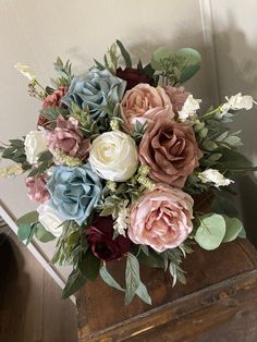 a bouquet of flowers sitting on top of a wooden box