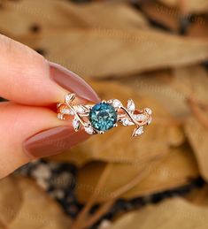 a woman's hand holding an engagement ring with a blue stone in the middle