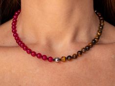 "Refine your style with this exquisite choker necklace, handcrafted with a striking combination of beaded Brown Tiger's Eye, Silver Hematite and Fuschia Jade strung on black knotted silk. Each bead is carefully selected for its natural variations, lending the piece a unique and nuanced identity. The black knotted silk provides a sophisticated backdrop for the shimmering beads, while the choker style adds a bold and contemporary touch to any outfit. Whether you're dressing up for a special occasion or elevating your everyday look, this handmade modern crystal jewelry is designed to inspire and uplift. Experience the transformative power of crystals with this stunning choker necklace. Brown tiger's eye is believed to promote grounding and stability, enhancing inner strength, courage, and sel 8mm Bead Necklaces For Gift, Elegant Choker With Natural Stones And Round Beads, Elegant Choker With Round Natural Stones, Elegant Multicolor Beaded Necklace With 8mm Beads, Healing Gemstone Beaded Necklaces, Beaded Necklaces With Round Beads For Healing, Gemstone Beaded Choker Necklace For Gifts, Gemstone Beaded Choker Necklace As Gift, Healing Beaded Necklaces With Round Beads