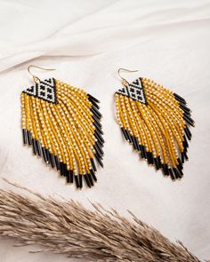 These handwoven beaded fringe earrings are made with premium Japanese Miyuki glass beads. They combine a striking geometric black and white woven triangle with two-toned contrasting maxi fringe at the bottom. Each strand of fringe is finished with a tubular black bead for added texture and dimension. These statement earrings have wonderful movement and a bohemian vibe that will certainly turn heads. This pair is hung from gold plated ear wires that include a silicone backing for added security. Our earrings are made my women artisans from vulnerable communities in Medellin, Colombia who receive fair working conditions and compensation for their skills as is detailed on our earring cards. Materials Miyuki Glass Beads Gold Plated Ear Wire Dimensions Length 3.25 Inches Width 1.75 Inches Bead Bottle, Bath Detox, Geometric Black And White, Fringe Earring, Beaded Fringe Earrings, Beaded Earring, Brick Stitch Earrings, Seed Bead Patterns, Earring Ideas