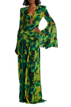 Radiate elegance in this emerald green, diamond-studded maxi floral dress with flared sleeves, intricate prints, and an alluring open back. The lush material adds to your charm, making it ideal for formal evenings, special events, and memorable gatherings. Handmade customization Fabric composition: 90% polyester fiber, 10% spandex Washing method: hand wash or dry clean Popular elements: printed Glamorous Chiffon Maxi Dress For Cocktail, Glamorous Floor-length Floral Print Dress, Glamorous Green Maxi Dress, Chic Bell Sleeve Maxi Dress For Party, Green Chiffon Floral Print Dress, Green Floral Print Maxi Dress For Party, Silk Flowy Maxi Dress For Cocktail, Chiffon Maxi Dress With Floral Print For Cocktails, Glamorous Floral Print Maxi Dress