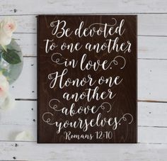 a wooden sign that says be devoted to one another in love