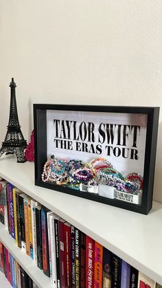 there is a book shelf with books on it and a sign that says taylor swift the eras tour