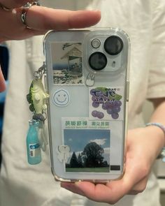 a person holding up an iphone case with pictures and charms attached to the back of it