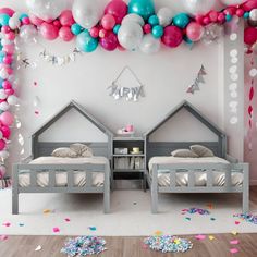 two twin beds in a room with balloons and confetti