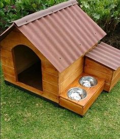 a wooden dog house with two bowls in it