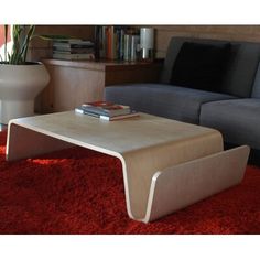 a living room with a couch, coffee table and bookshelf in the corner