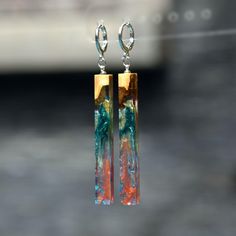 the earrings are made with glass and gold plated metal, which is hanging from silver hooks