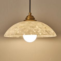 a light fixture hanging from the ceiling in a room with beige walls and flooring