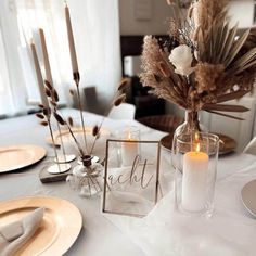 the table is set with candles, plates and napkins