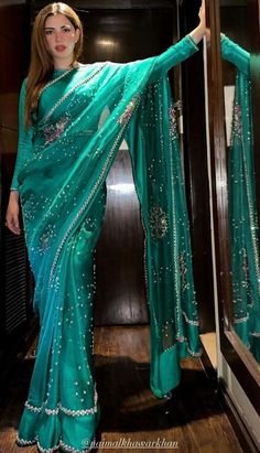 a woman in a green sari posing for the camera