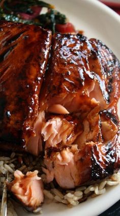 a white plate topped with meat and rice on top of a red table cloth next to a fork