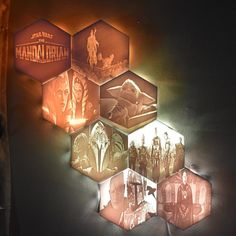 three hexagonal lights are hanging on the wall in front of a dark background